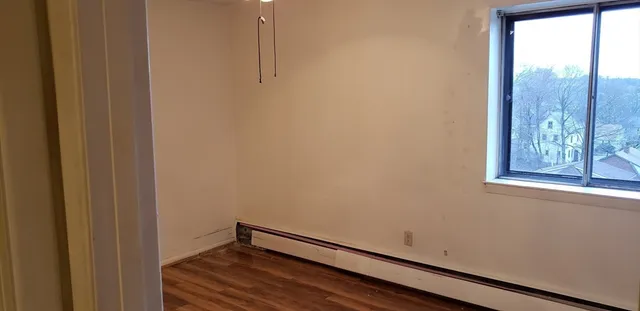 a view of a room with wooden floor and windows