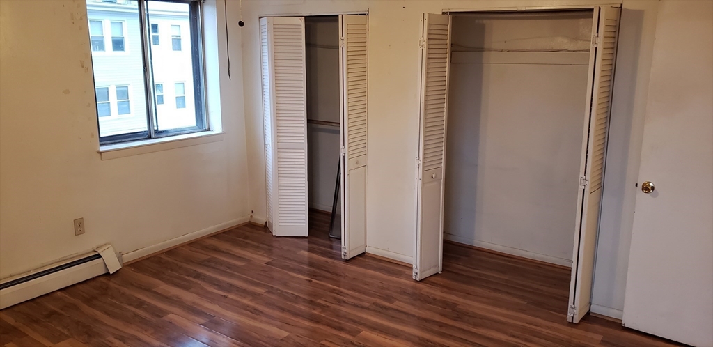 6 Hayes Road, Unit 25 Boston, MA 02131 - Photo 8 of 39 an empty room with wooden floor and windows