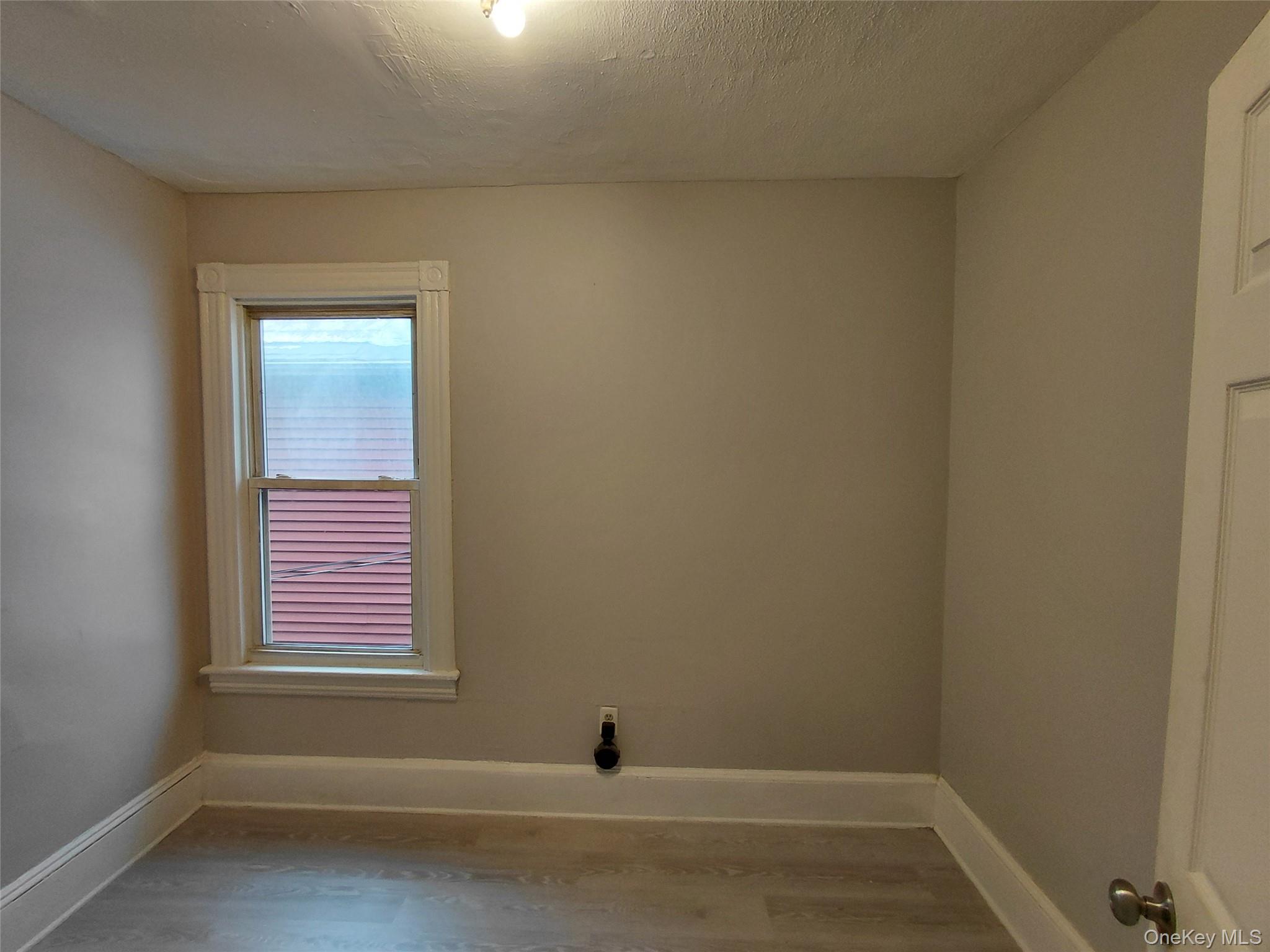 67 Greenkill Avenue, Unit A2 Kingston, NY 12401 - Photo 9 of 13 Spare room with wood finished floors and a textured ceiling