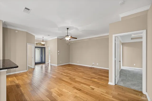 a view of a kitchen with kitchen island stainless steel appliances wooden floor and living room view