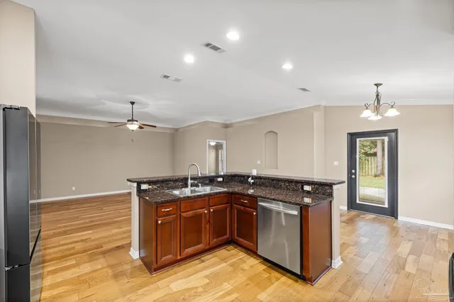a kitchen with stainless steel appliances granite countertop a sink refrigerator and cabinets