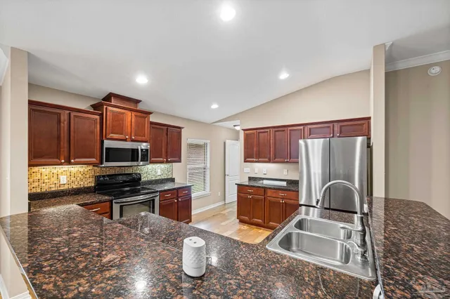 a kitchen with stainless steel appliances granite countertop a sink and stove