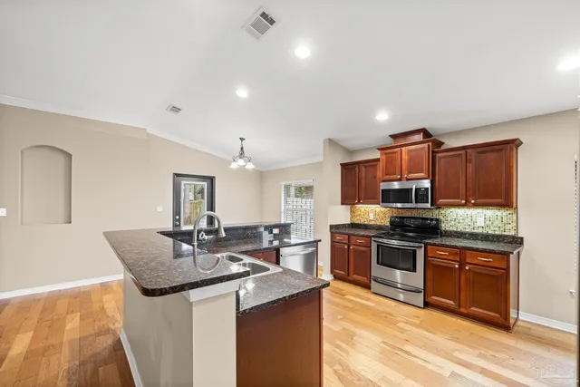 a view of kitchen with refrigerator microwave and stove