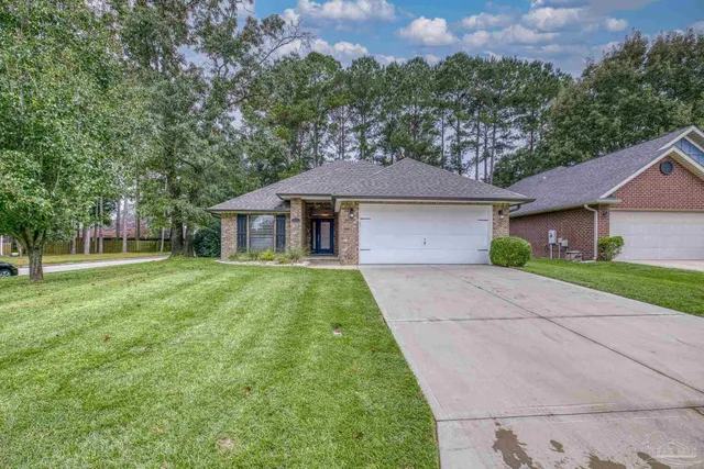 a front view of a house with a yard and trees