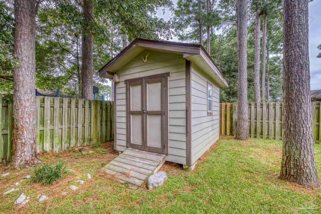 a view of a house with a yard and wooden fence