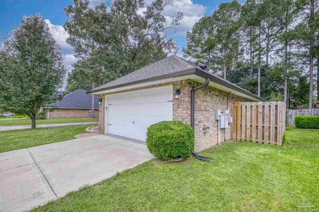 a view of a house with a small yard and a large tree