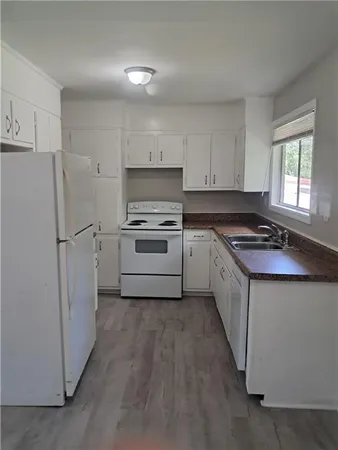 a kitchen with white cabinets and white appliances