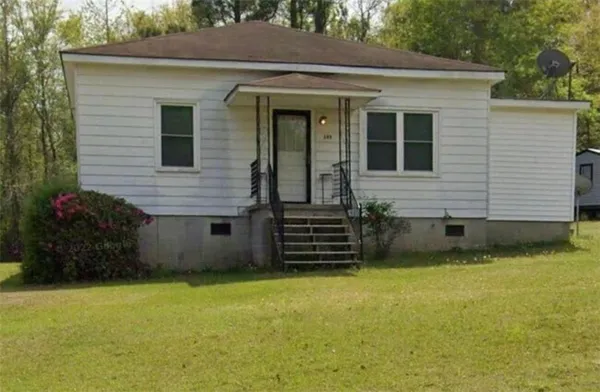 a front view of a house with a garden