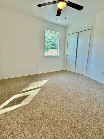 an empty room with chandelier fan
