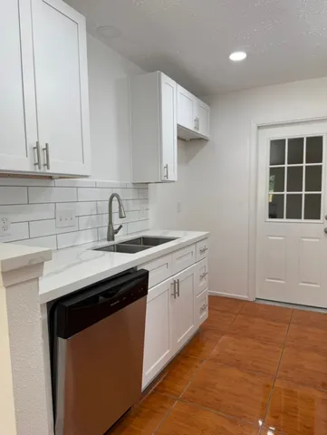 a kitchen with stainless steel appliances granite countertop a sink stove and cabinets