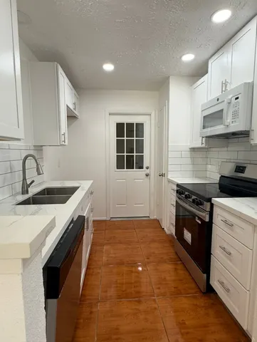 a kitchen with a sink stove and cabinets