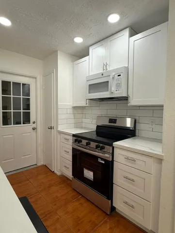 a kitchen with stainless steel appliances granite countertop a stove and a refrigerator