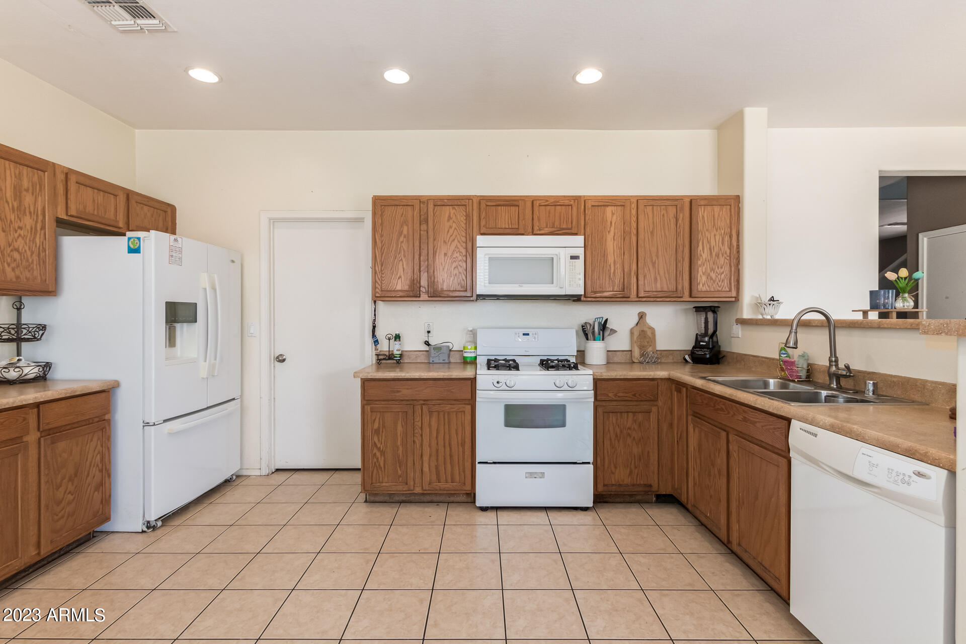 7317 West Darrel Road Laveen, AZ 85339 - Photo 4 of 13 a kitchen with a sink a stove top oven and white cabinets
