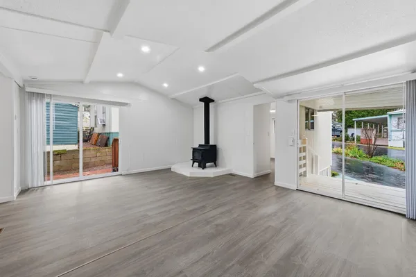 an empty room with wooden floor and a fireplace