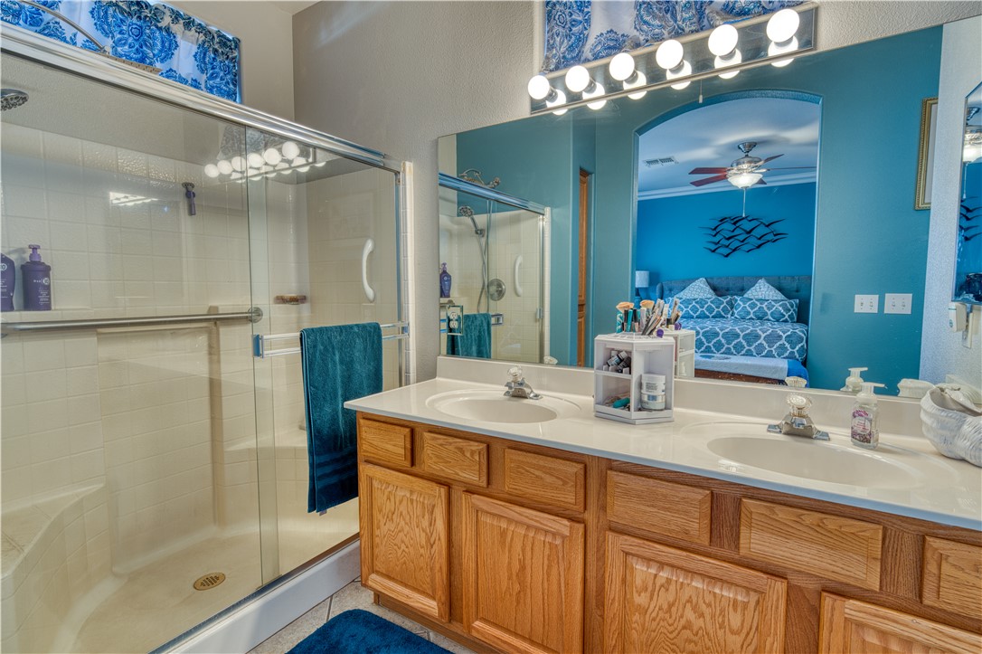 2341 Half Moon Way Bullhead City, AZ 86442 - Photo 11 of 35 Ensuite bathroom featuring a shower stall, double vanity, a ceiling fan, and a textured wall