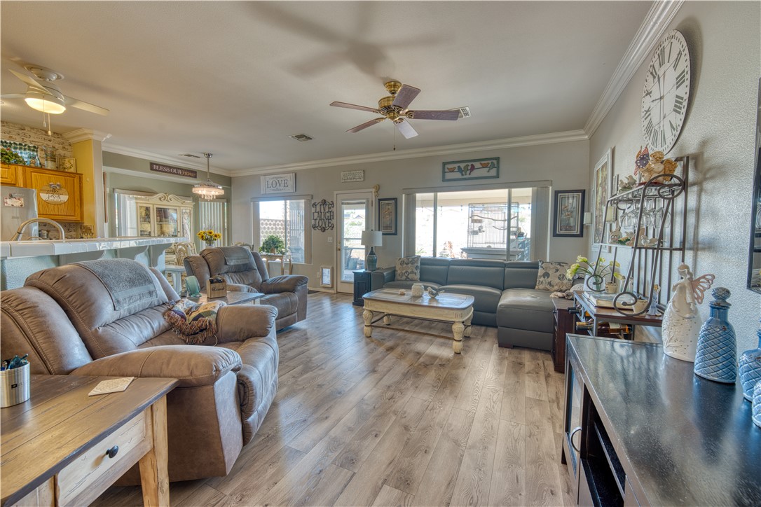 2341 Half Moon Way Bullhead City, AZ 86442 - Photo 14 of 35 Living room with crown molding, wood finished floors, ceiling fan, and healthy amount of natural light