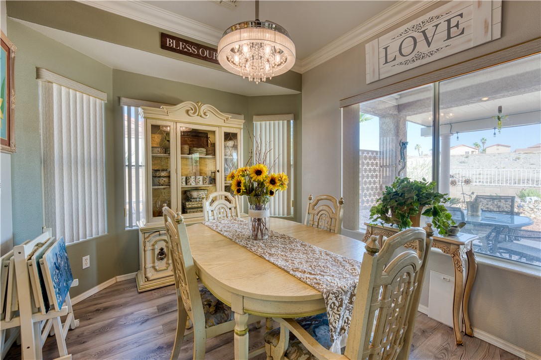 2341 Half Moon Way Bullhead City, AZ 86442 - Photo 18 of 35 Dining room featuring wood finished floors, ornamental molding, and a chandelier
