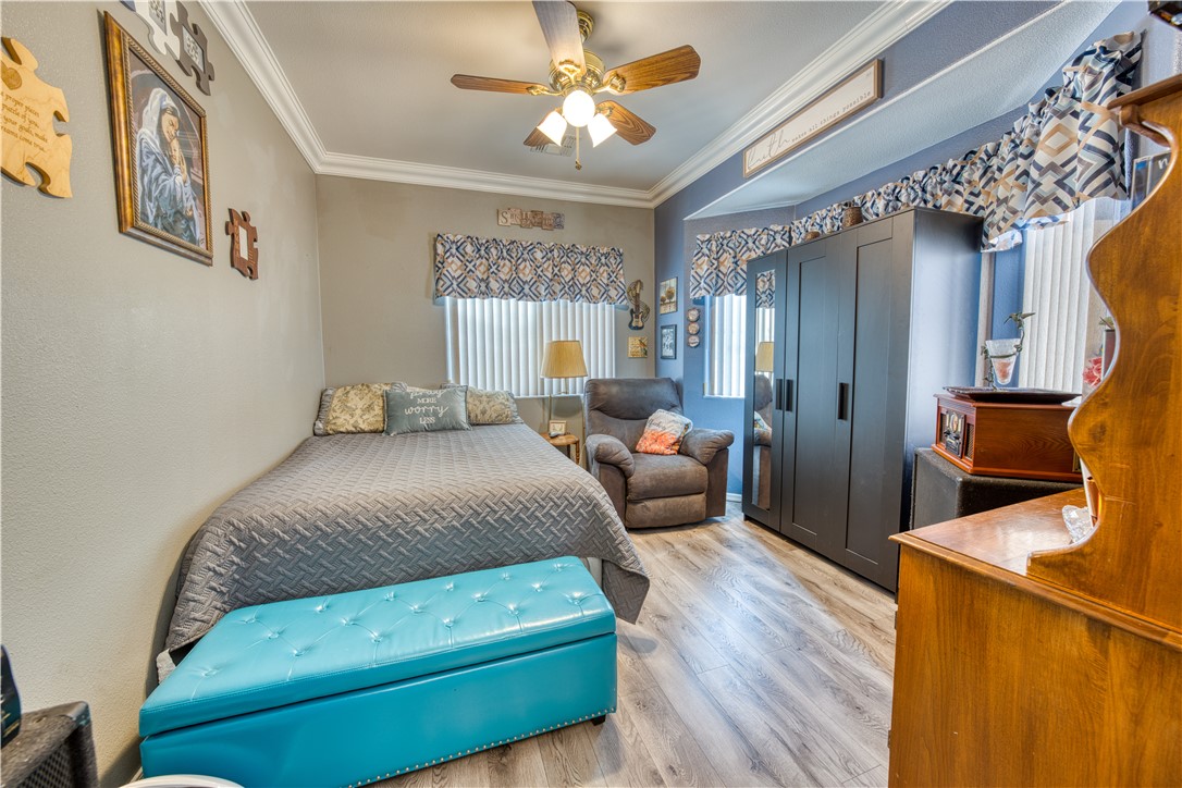 2341 Half Moon Way Bullhead City, AZ 86442 - Photo 5 of 35 Bedroom with crown molding, a closet, wood finished floors, and a ceiling fan