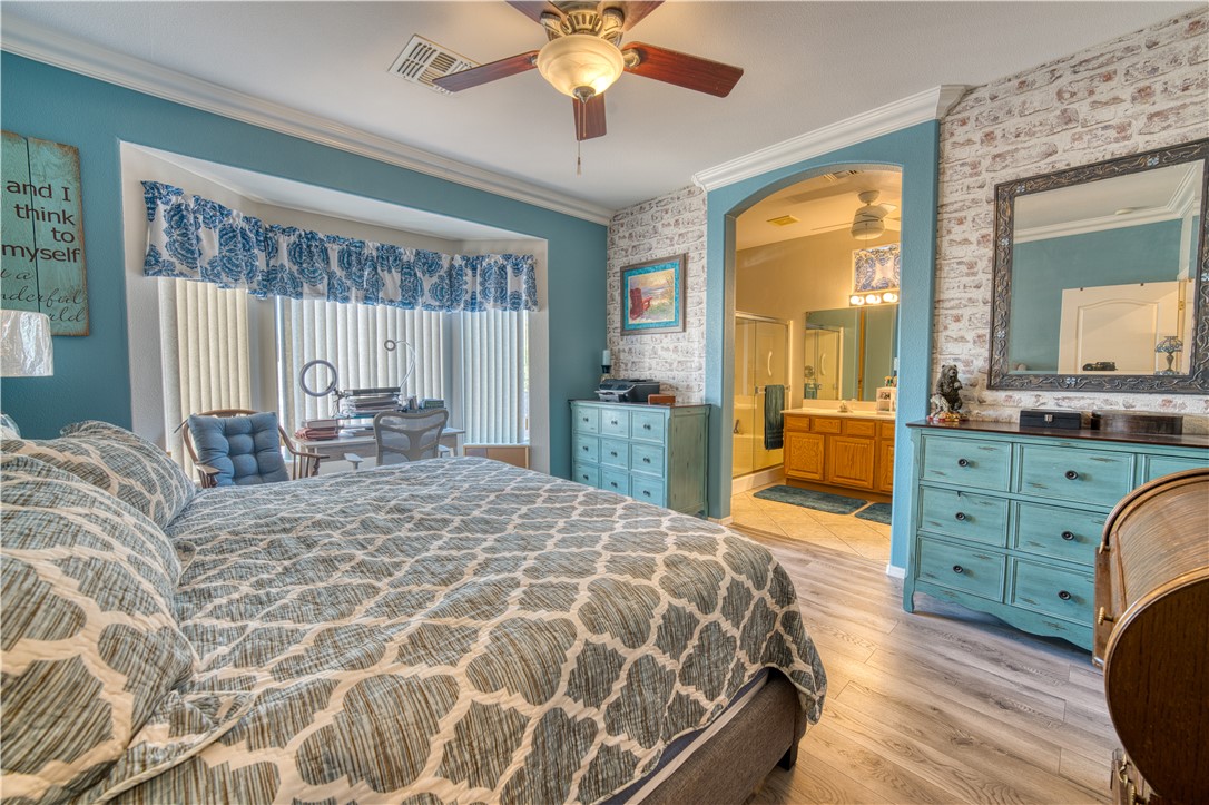 2341 Half Moon Way Bullhead City, AZ 86442 - Photo 8 of 35 Bedroom featuring crown molding, light wood-style flooring, a ceiling fan, and ensuite bath