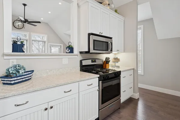 a kitchen with stainless steel appliances granite countertop a stove a microwave and wooden floors