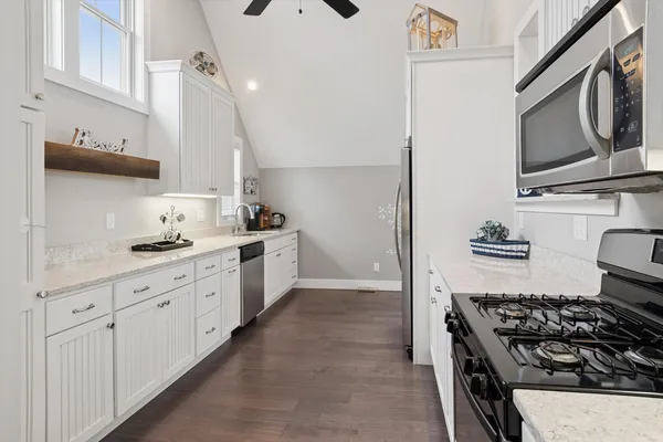 a kitchen with white cabinets and appliances