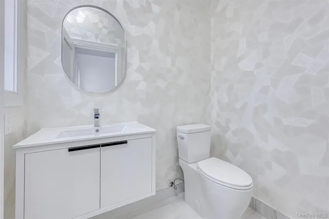 a bathroom with a toilet a sink and mirror