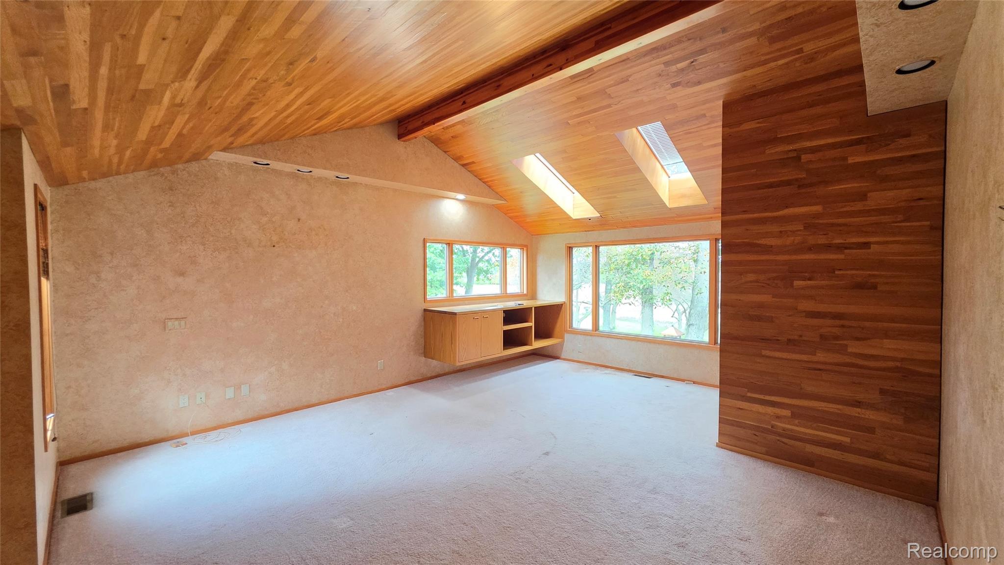 2551 Patterson Lk Road Pinckney, MI 48169 - Photo 16 of 37 Sloping wood-paneled ceiling with exposed beam, multiple skylights, and recessed lighting