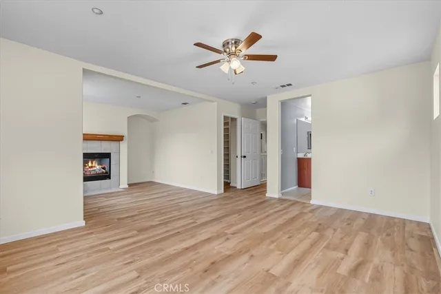 a view of an empty room with a ceiling fan and window