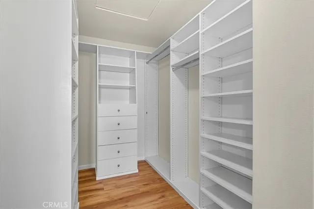a view of walk in closet with empty racks