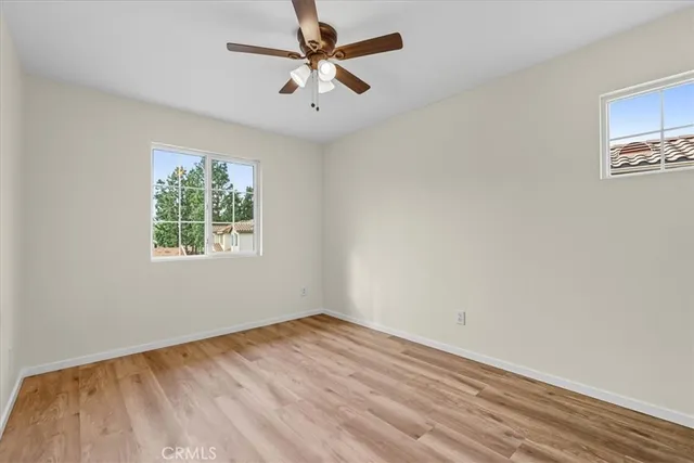 an empty room with a window and a ceiling fan