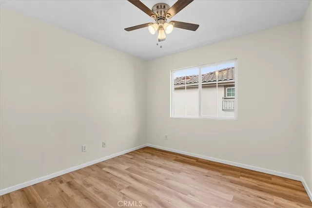 a view of a room with a ceiling fan and wooden floor