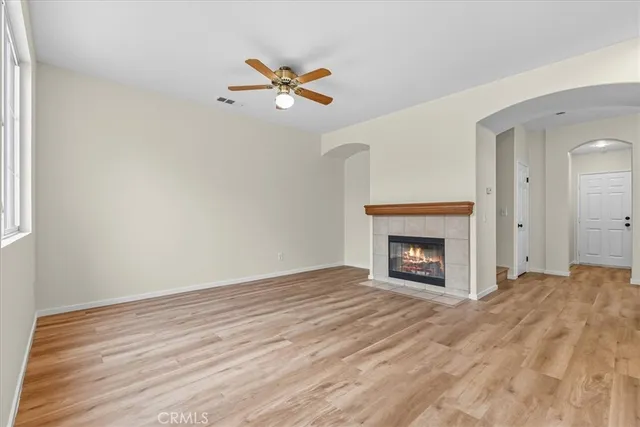a view of an empty room with window and fire place