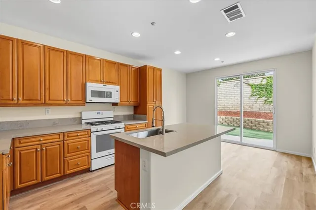 a kitchen with wooden cabinets sink and stove