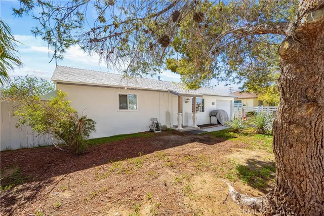 a view of a house with backyard and a tree