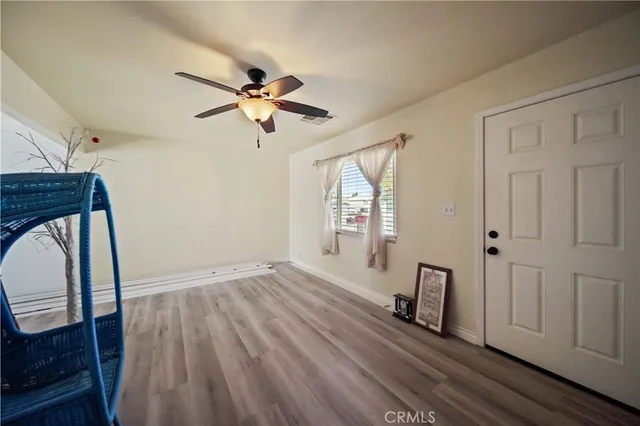 a view of a livingroom with wooden floor and a ceiling fan