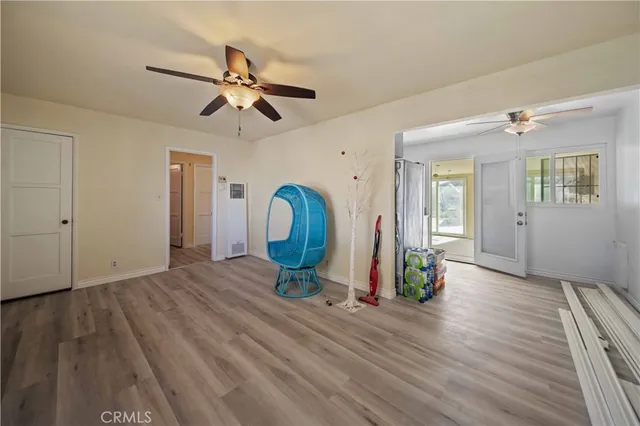 a view of a room with wooden floor gym equipment and a ceiling fan