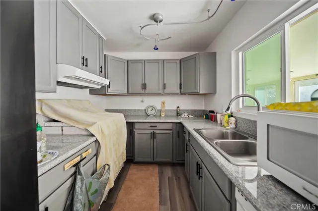 a kitchen with a sink a stove and cabinets