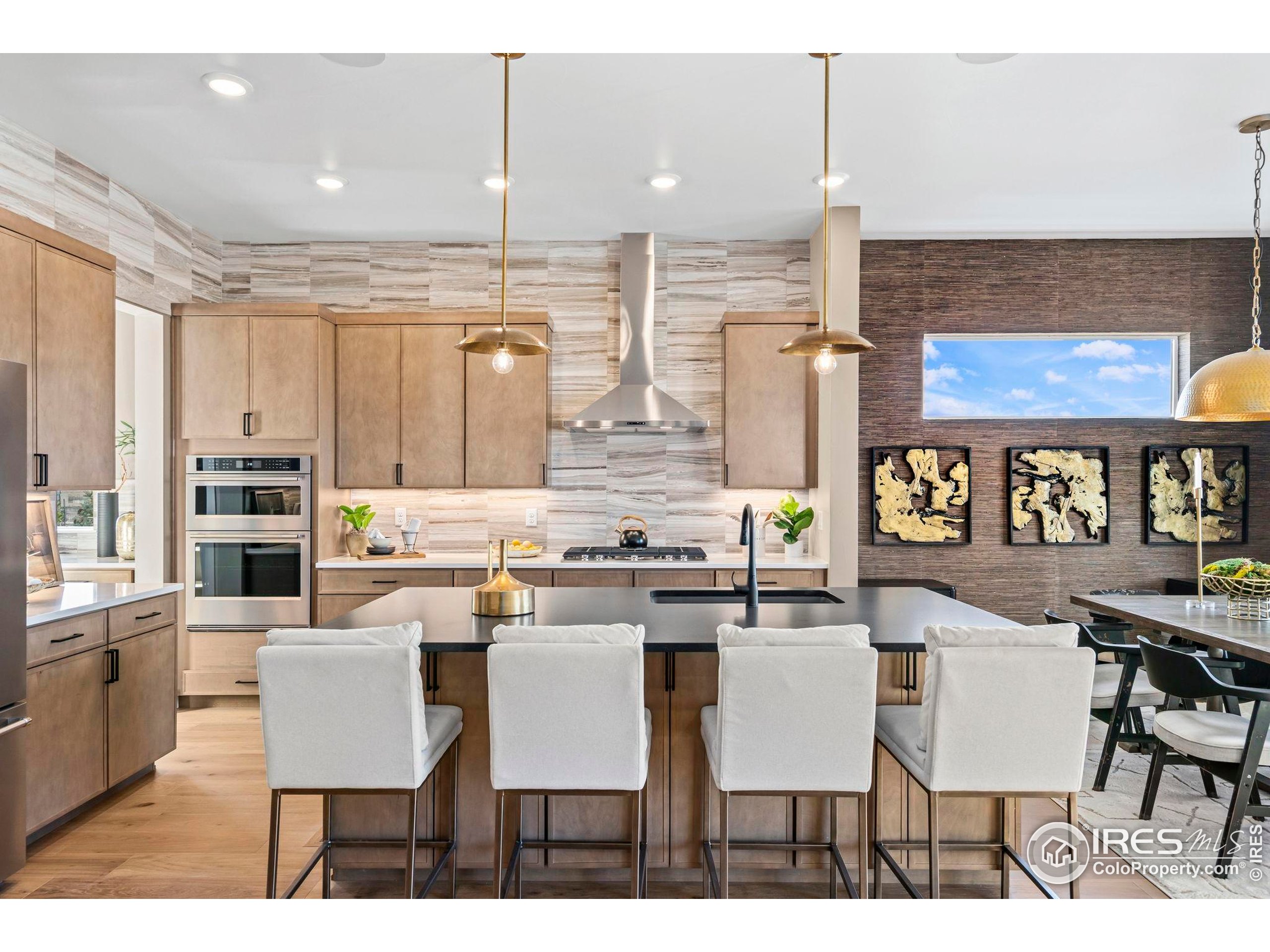 3016 Windward Way Fort Collins, CO 80524 - Photo 11 of 49 a dining hall with stainless steel appliances kitchen island granite countertop a dining table chairs and view living room