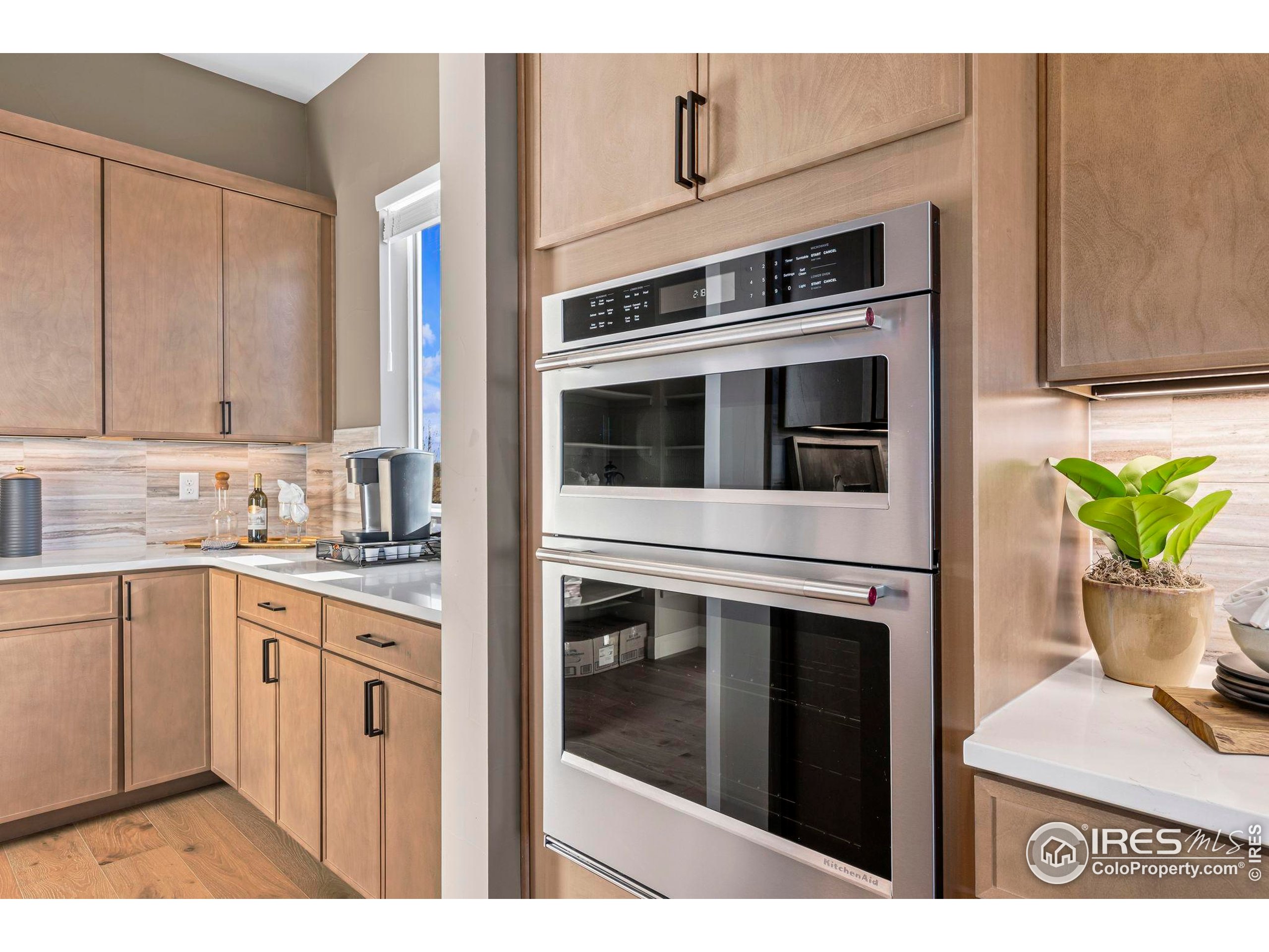 3016 Windward Way Fort Collins, CO 80524 - Photo 20 of 49 a kitchen with stainless steel appliances a stove microwave and cabinets