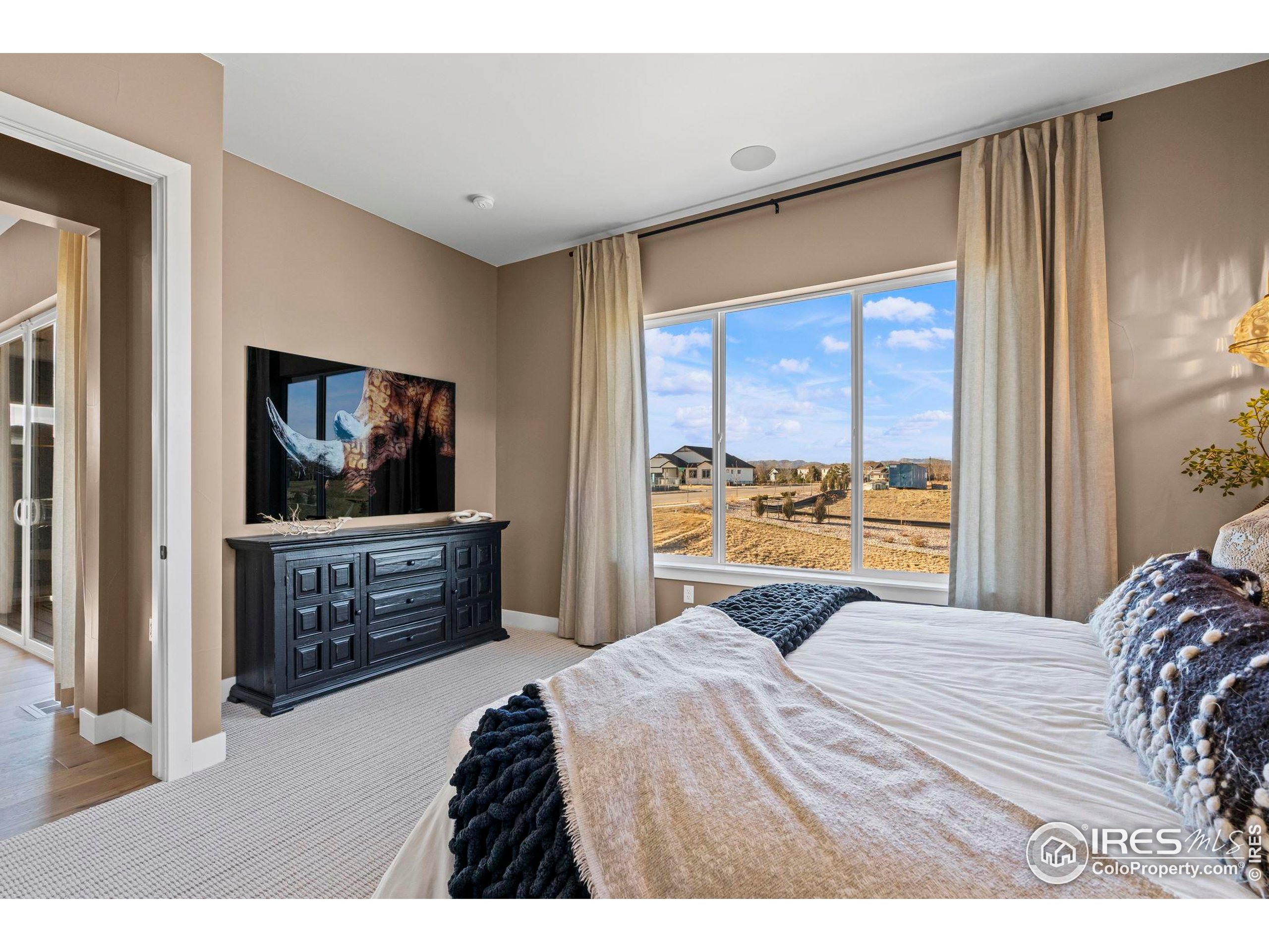 3016 Windward Way Fort Collins, CO 80524 - Photo 24 of 49 a bedroom with a bed and a flat screen tv