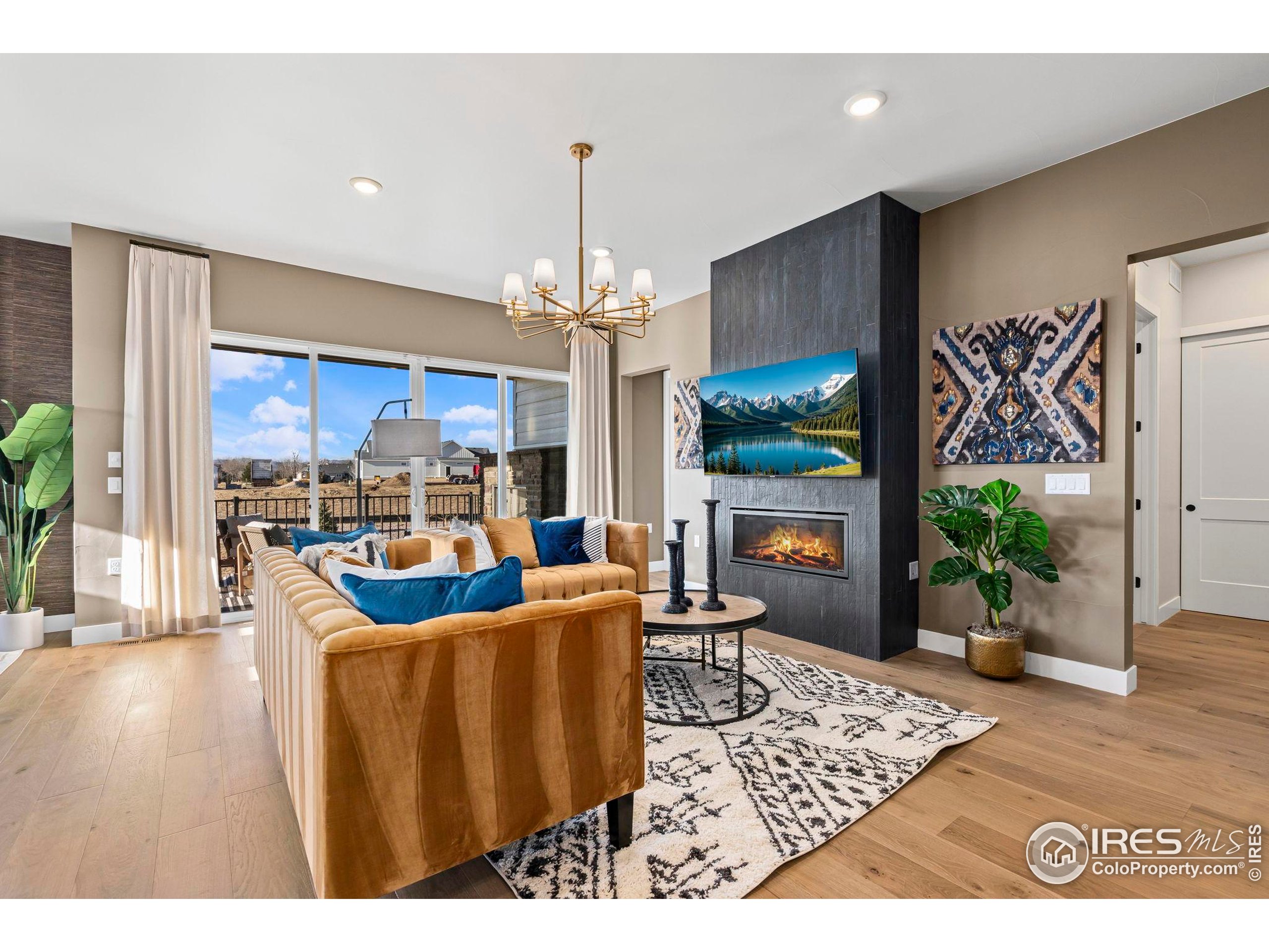 3016 Windward Way Fort Collins, CO 80524 - Photo 6 of 49 a living room with fireplace furniture and a chandelier