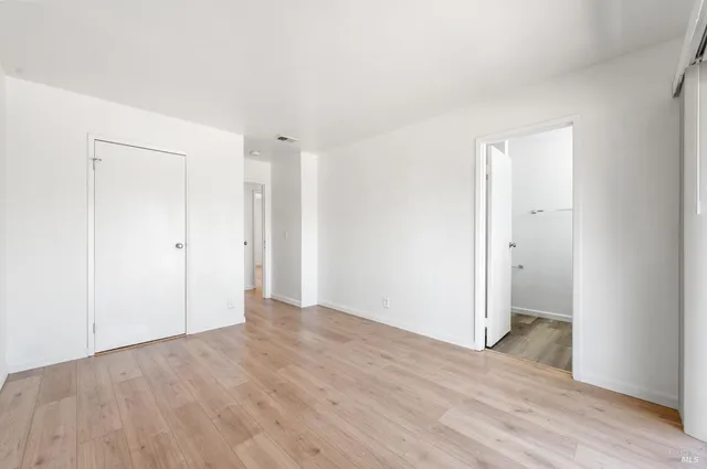 a view of an empty room with wooden floor