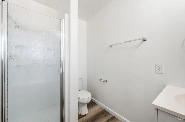 a bathroom with a granite countertop toilet and a sink