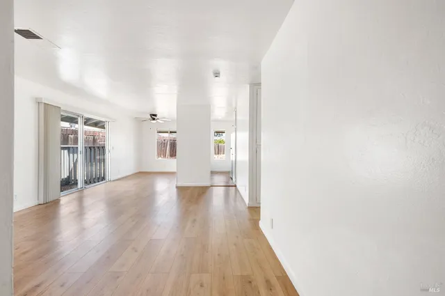 a view of a big room with wooden floor and windows