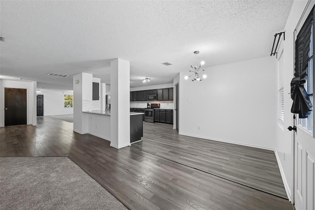 1130 Annie Oakley Drive Anna, TX 75409 - Photo 11 of 32 a view of a hallway with wooden floor and a kitchen