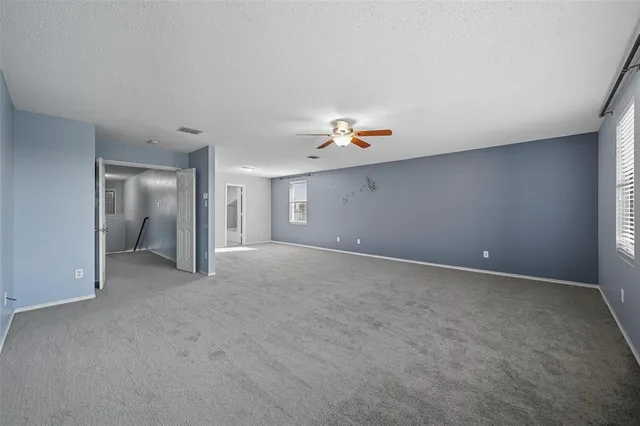 a view of a livingroom with a ceiling fan and window