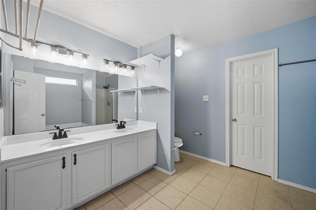 1130 Annie Oakley Drive Anna, TX 75409 - Photo 16 of 32 a bathroom with a double vanity sink mirror and toilet