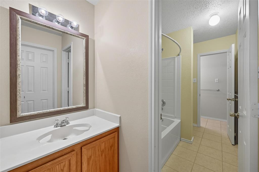 1130 Annie Oakley Drive Anna, TX 75409 - Photo 20 of 32 a bathroom with a granite countertop sink and a mirror