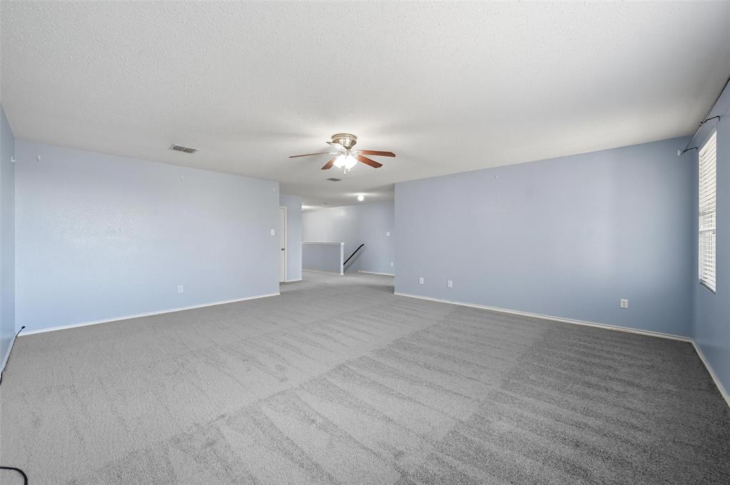 1130 Annie Oakley Drive Anna, TX 75409 - Photo 26 of 32 a view of an empty room with a chandelier fan