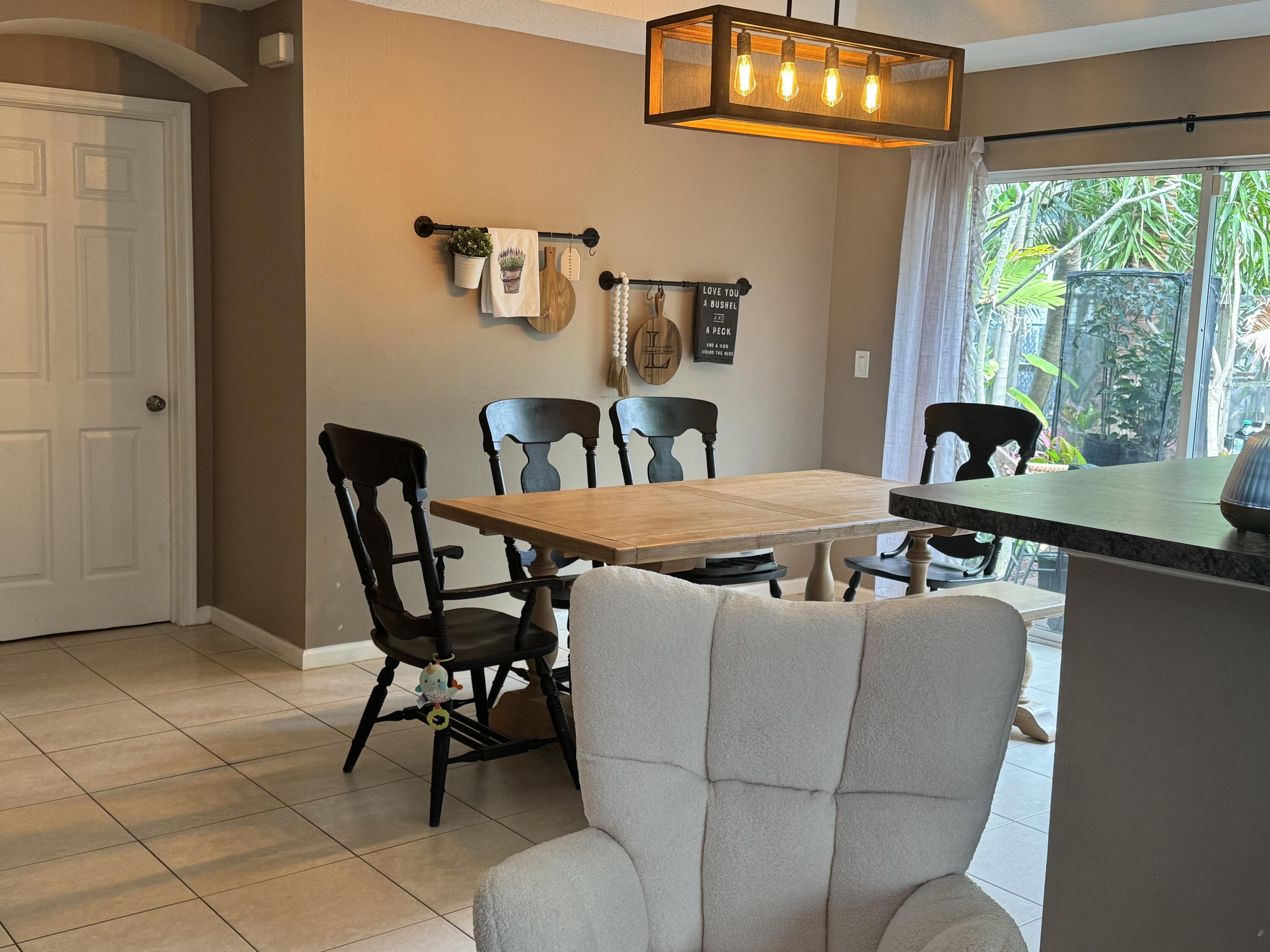 4571 Southeast Murray Cove Circle Stuart, FL 34997 - Photo 11 of 35 a view of a dining room with furniture and a chandelier